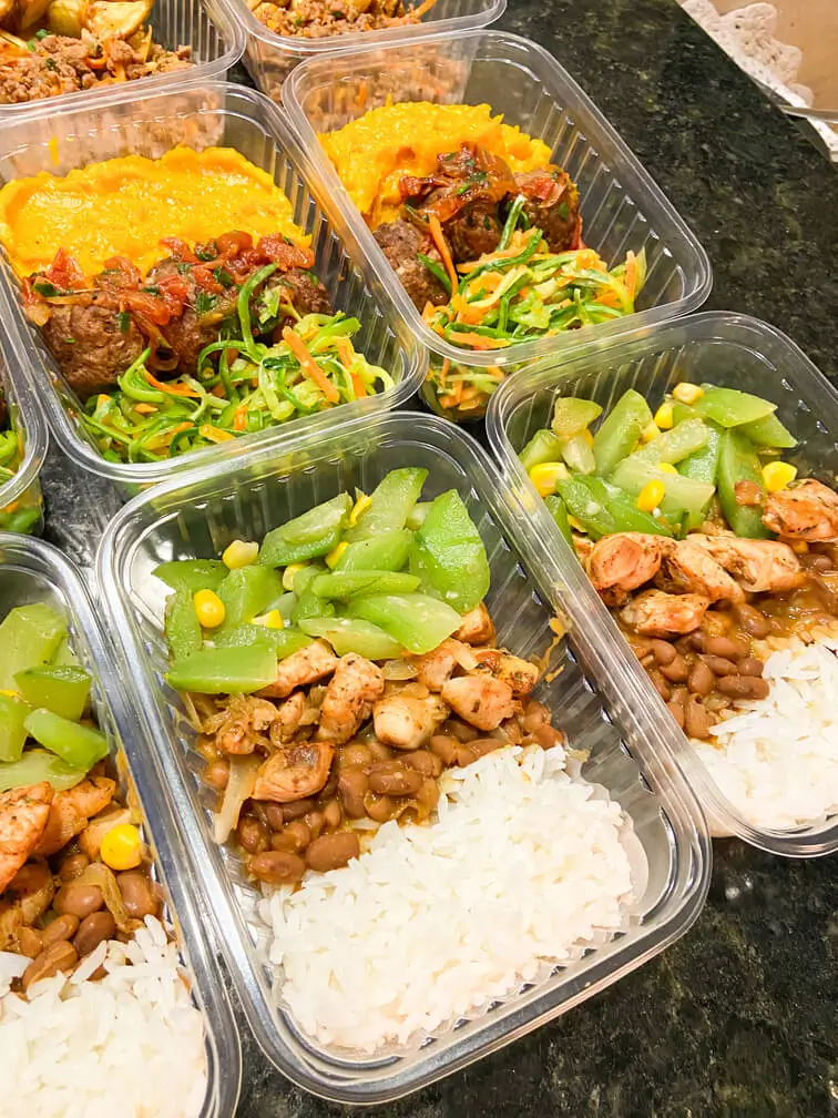 Detalhes das marmitas com purê, carne e saladas